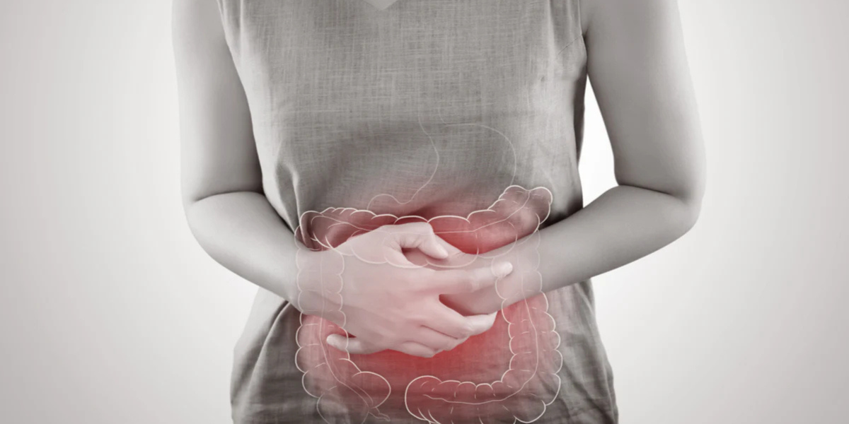 Person holding lower abdomen with translucent colon overlay highlighted red to indicate constipation pain.