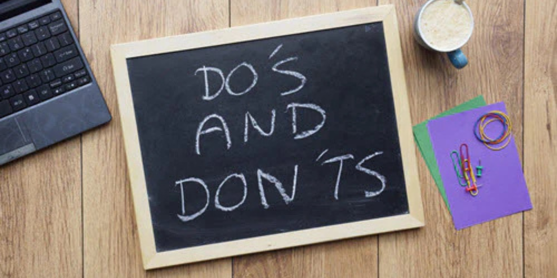 Chalkboard on a wooden desk beside a laptop and coffee cup reading DO'S AND DON'TS, with paperclips and colored cards.