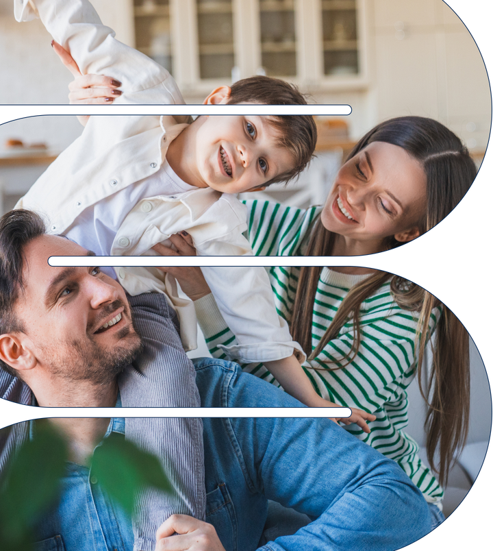 Parents playfully lift their smiling young son in a bright kitchen, a happy family moment
